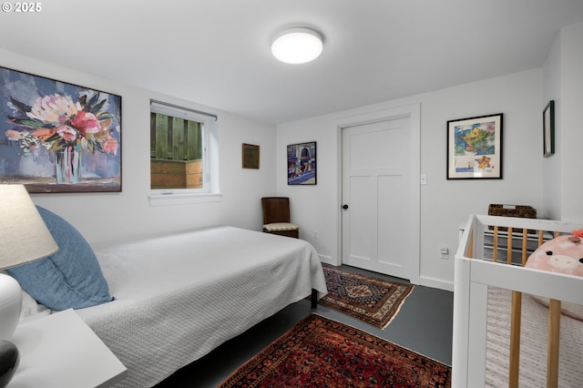 bedroom with concrete floors and baseboards