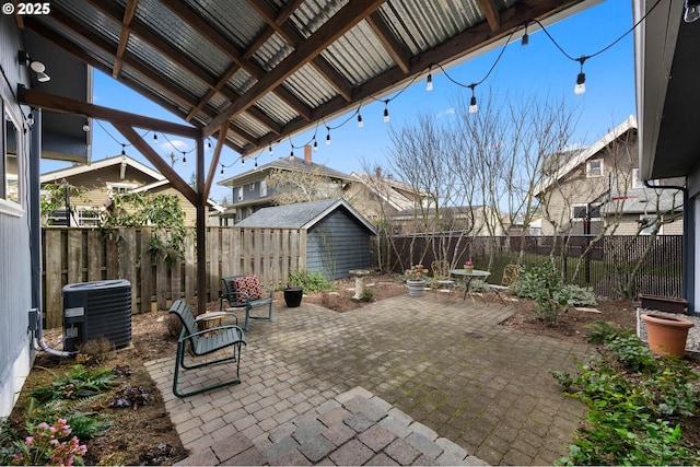 view of patio featuring cooling unit, an outdoor structure, a fenced backyard, and a shed