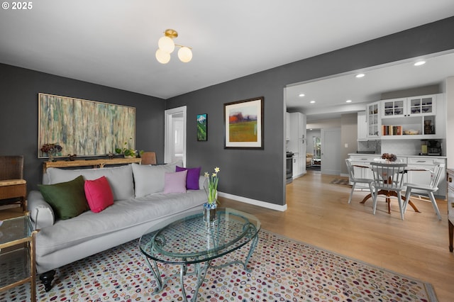 living room with recessed lighting, baseboards, and light wood finished floors