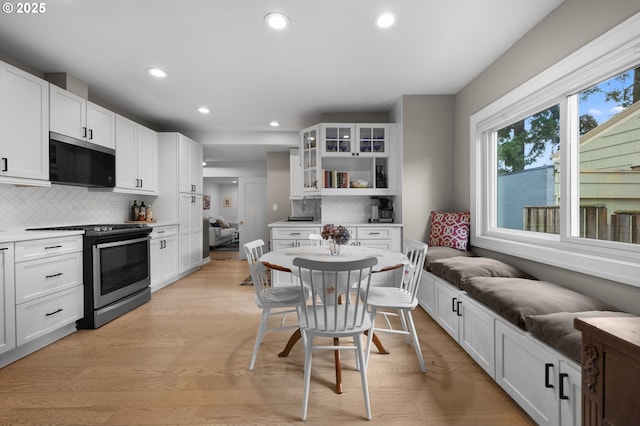 kitchen with glass insert cabinets, appliances with stainless steel finishes, and white cabinetry