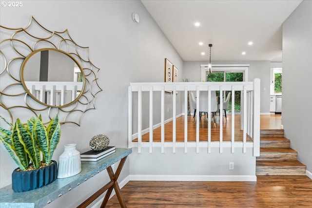 staircase featuring baseboards, wood finished floors, and recessed lighting