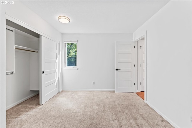 unfurnished bedroom with baseboards, carpet floors, and a closet