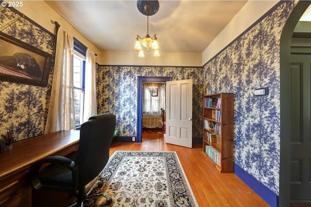 369 37th St, Astoria, OR 97103 - office area featuring wood finished floors, wallpapered walls, a chandelier, and arched walkways