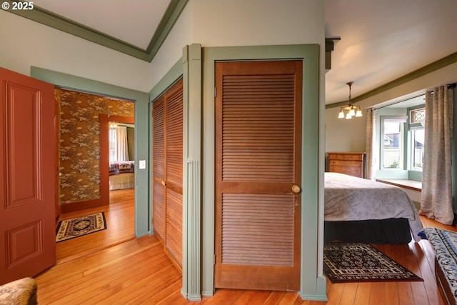 369 37th St, Astoria, OR 97103 - bedroom featuring light wood-type flooring, a chandelier, crown molding, and baseboards