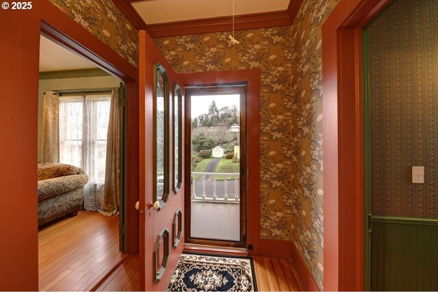 369 37th St, Astoria, OR 97103 - entryway featuring wallpapered walls, ornamental molding, wood finished floors, and a chandelier