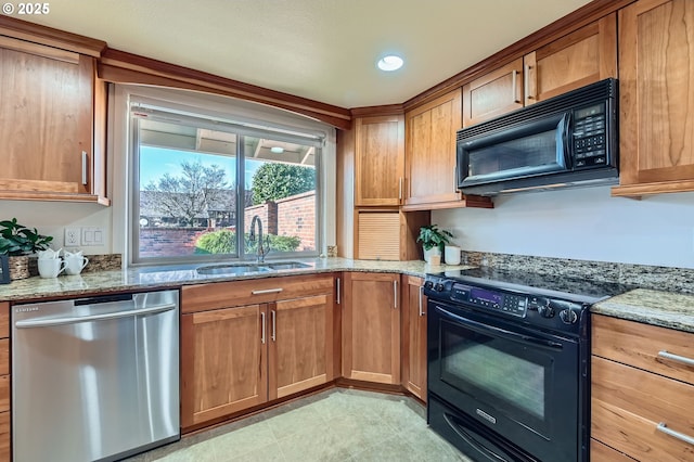 kitchen with sink, light stone counters, and black appliances