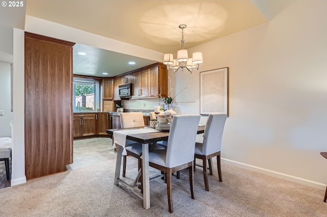 carpeted dining room featuring an inviting chandelier