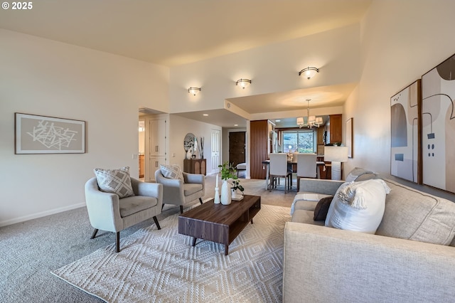 carpeted living room featuring a chandelier