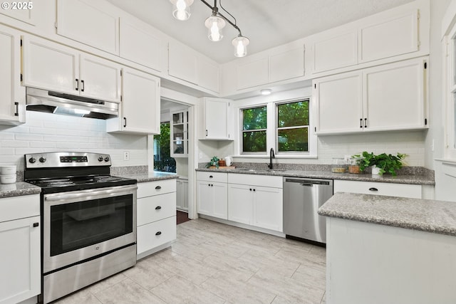 380 W Arlington St, Gladstone, OR 97027 - kitchen with stainless steel appliances, under cabinet range hood, white cabinetry, tasteful backsplash, and decorative light fixtures