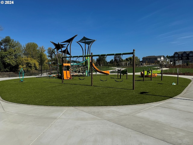 community play area with a yard and fence