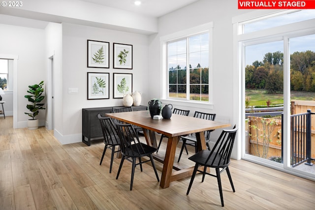 dining room with light wood finished floors, plenty of natural light, baseboards, and recessed lighting