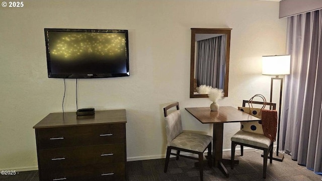 dining area with dark carpet and baseboards