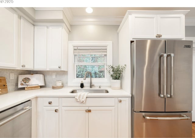 621 NE Randall Ave, Portland, OR 97232 - kitchen featuring appliances with stainless steel finishes, a sink, white cabinets, light countertops, and ornamental molding