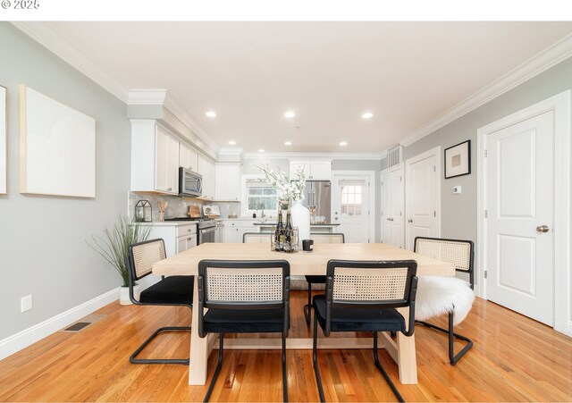 621 NE Randall Ave, Portland, OR 97232 - dining space featuring light wood finished floors, crown molding, recessed lighting, and baseboards