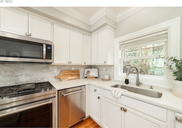 621 NE Randall Ave, Portland, OR 97232 - kitchen featuring appliances with stainless steel finishes, a sink, ornamental molding, light countertops, and tasteful backsplash