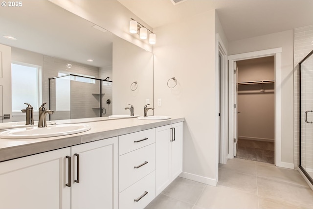 bathroom with tile patterned flooring, vanity, and a shower with shower door