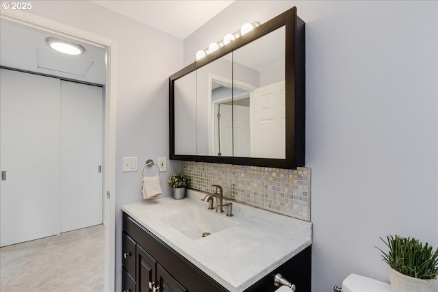 bathroom with toilet, backsplash, and vanity