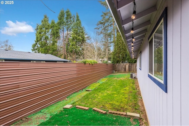 view of yard with central air condition unit and a fenced backyard