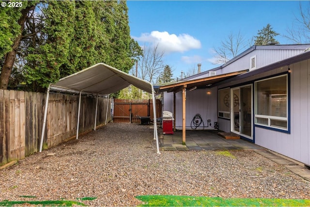 view of yard with a gate, fence, and a detached carport