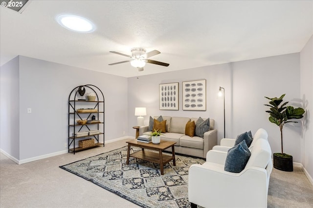 carpeted living area with a textured ceiling, baseboards, and a ceiling fan