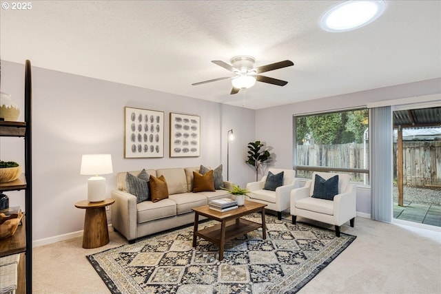 living room featuring ceiling fan, baseboards, and carpet flooring