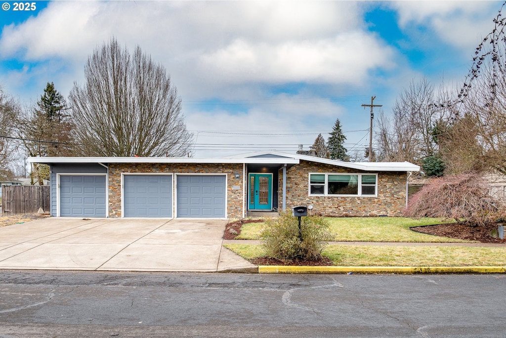 ranch-style home featuring a garage and a front lawn