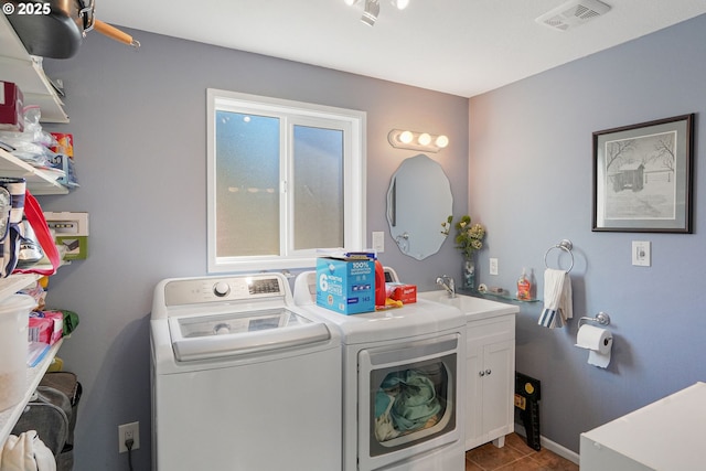 clothes washing area featuring light tile patterned flooring, washer and dryer, and sink