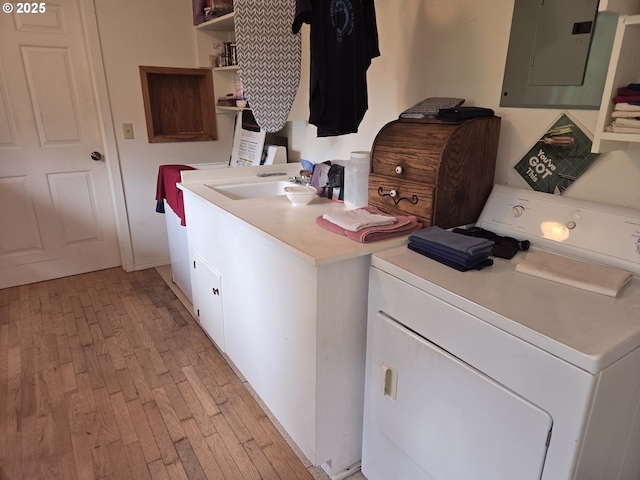 laundry room featuring electric panel, washer and clothes dryer, light hardwood / wood-style floors, and sink