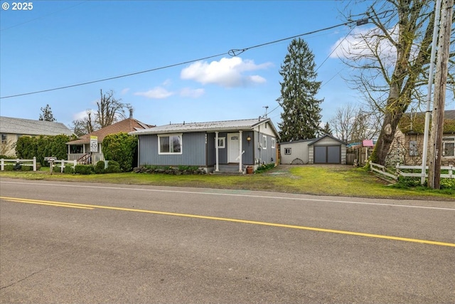 view of front of house with an outbuilding, a storage shed, a front lawn, and fence