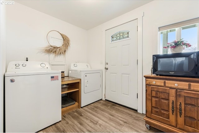 laundry room featuring laundry area, washing machine and dryer, and light wood finished floors