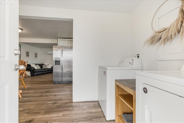 washroom with washer and dryer, wood finished floors, and laundry area