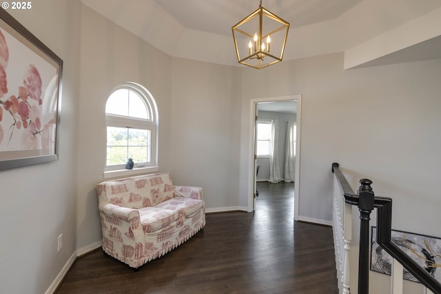 sitting room with a chandelier, an upstairs landing, dark wood-style floors, and baseboards