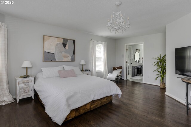 bedroom featuring a chandelier, wood finished floors, baseboards, and connected bathroom