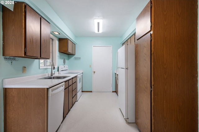 kitchen with white appliances, light countertops, baseboards, and a sink