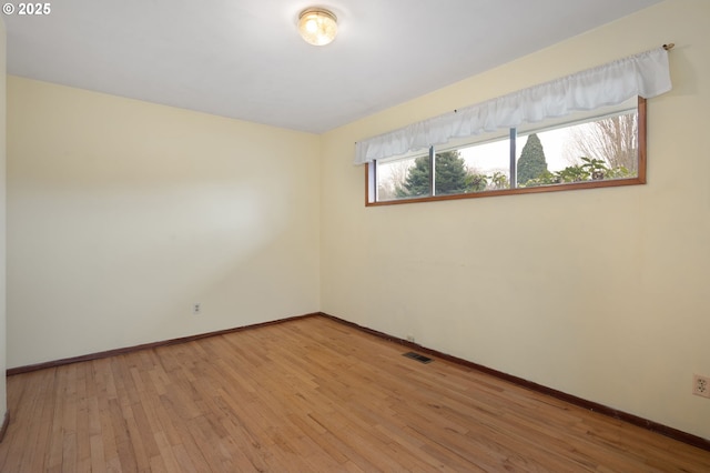 spare room with visible vents, baseboards, and light wood-style floors