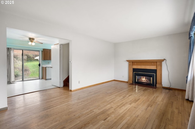 unfurnished living room featuring baseboards, a fireplace with flush hearth, ceiling fan, and light wood finished floors