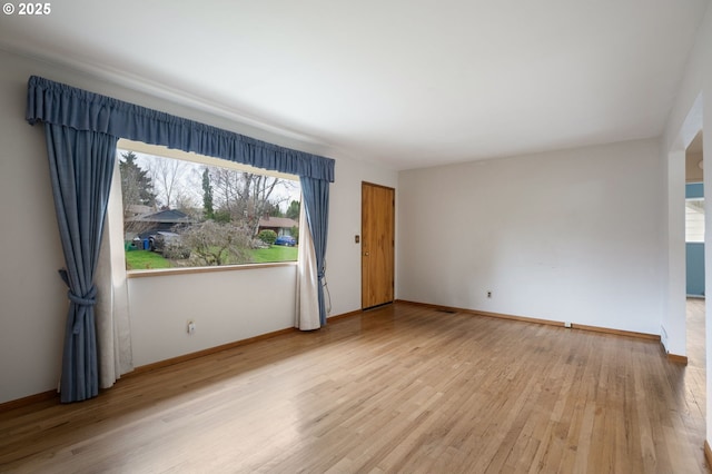 unfurnished room featuring baseboards and wood finished floors