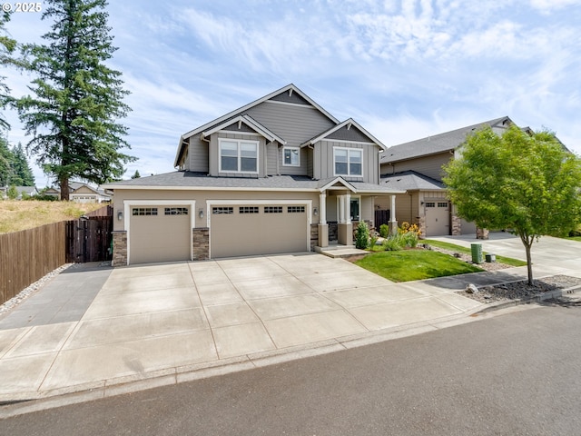 13317 NE 60th Ave, Vancouver, WA 98686 - craftsman-style house with stone siding, an attached garage, concrete driveway, and board and batten siding