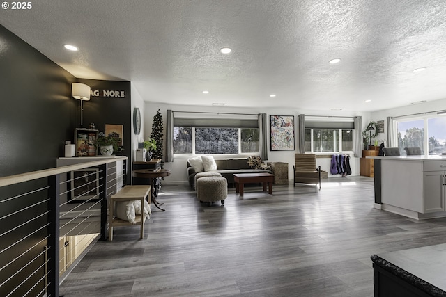 living room with recessed lighting, dark wood-style floors, and a textured ceiling