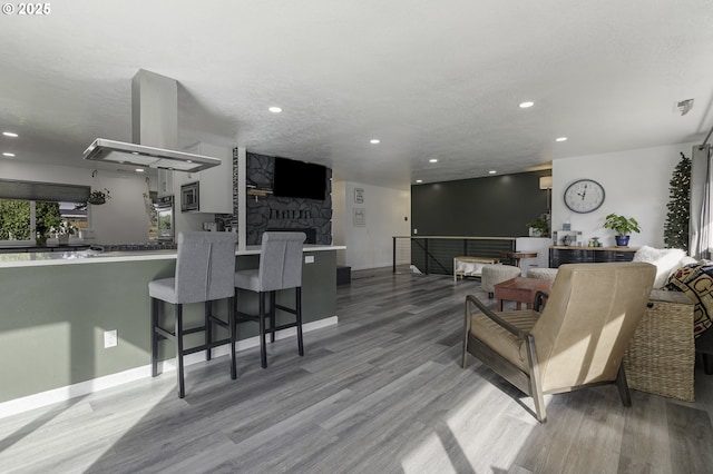 living room with visible vents, recessed lighting, and wood finished floors