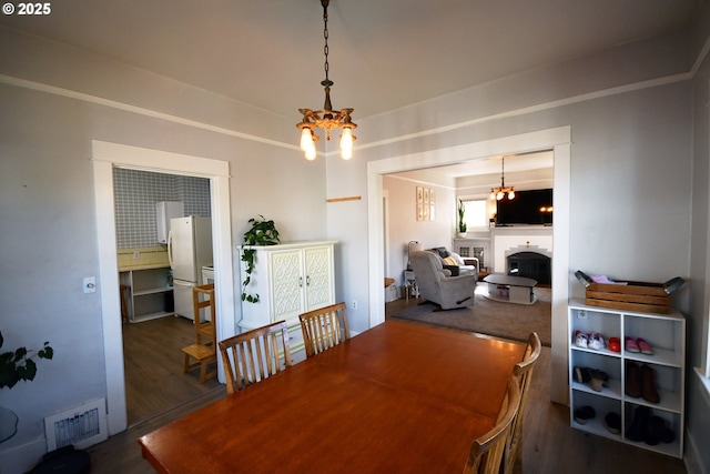 609 E 10th St, The Dalles, OR 97058 - dining area featuring a chandelier, wood finished floors, and a fireplace