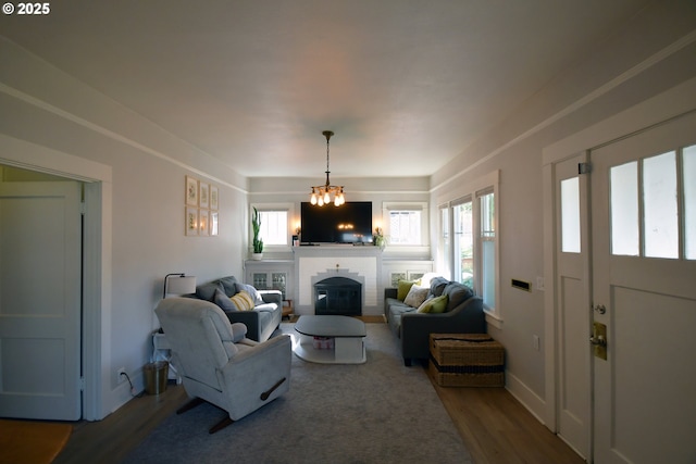 609 E 10th St, The Dalles, OR 97058 - living room featuring wood finished floors, a brick fireplace, and a chandelier