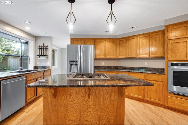 20752 SW 104th Ave, Tualatin, OR 97062 - kitchen featuring stainless steel appliances, brown cabinets, light wood-type flooring, a kitchen island, and recessed lighting