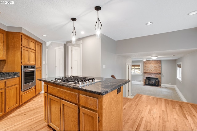 20752 SW 104th Ave, Tualatin, OR 97062 - kitchen with appliances with stainless steel finishes, light wood-type flooring, a kitchen island, recessed lighting, and hanging light fixtures