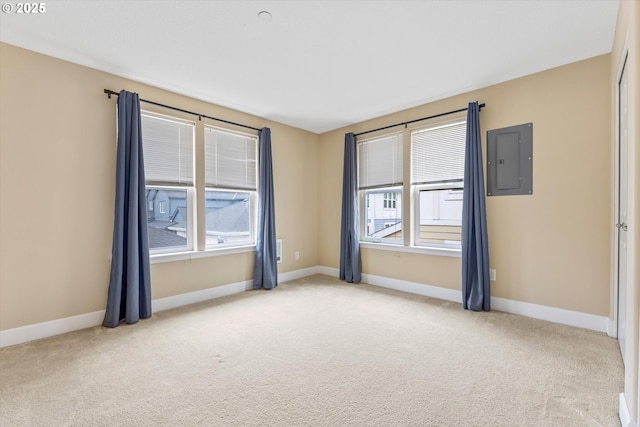 carpeted spare room with baseboards and electric panel