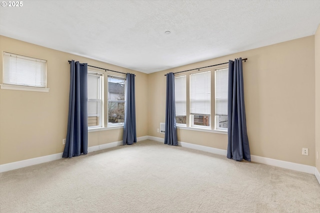 carpeted spare room with baseboards and a textured ceiling