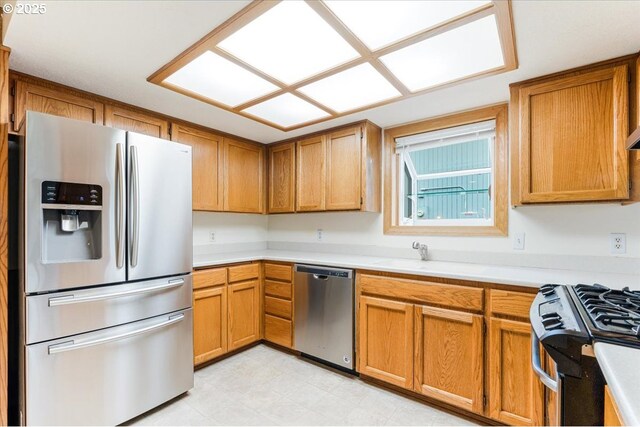11347 SE Abby Ln, Clackamas, OR 97015 - kitchen featuring appliances with stainless steel finishes, light countertops, a sink, and brown cabinets