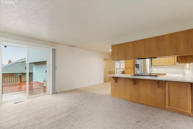 11347 SE Abby Ln, Clackamas, OR 97015 - kitchen with appliances with stainless steel finishes, a peninsula, light colored carpet, light countertops, and recessed lighting