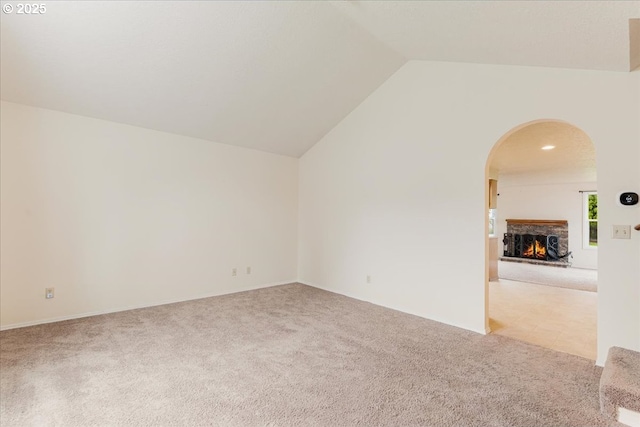 11347 SE Abby Ln, Clackamas, OR 97015 - carpeted spare room featuring arched walkways, lofted ceiling, and a lit fireplace