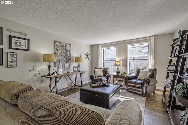 living area with a textured ceiling, baseboards, and wood finished floors